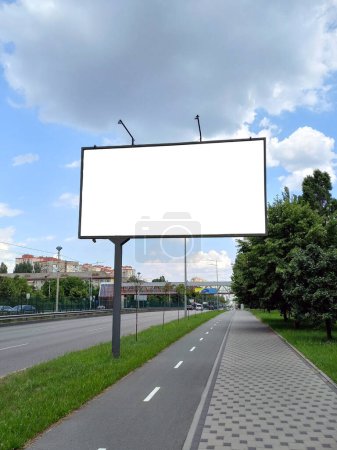 Bigboard auf der Straße mit einer Vorlage für isolierte weiße Fläche zum Einfügen von Werbung. Bigboard auf einem geteilten Bürgersteig in der Perspektive