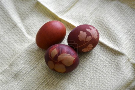 Close-up of eggs painted with patterns on a single-colored towel. View from above. Christian traditions
