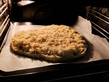 A large pancake lies in the kitchen oven ready to be cooked. Homemade sweet pastries with your own hands