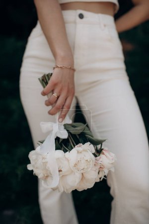 beautiful young bride with bouquet of flowers in brides hands