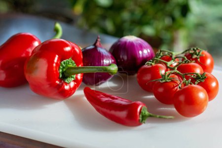 Photo for Red tomato, paprika, chili pepper and green onion, farm organic vegetables on a cooking board. Vegetarian healthy food. Nutritionology. Soft selective focus. - Royalty Free Image