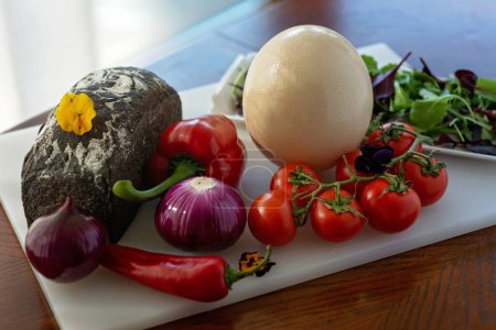 Foto de Pan casero, huevo de avestruz y verduras, pimentón, tomates, chile, cebolla, ensalada. Ingredientes para hacer una tortilla, shakshuka. Enfoque selectivo suave. - Imagen libre de derechos