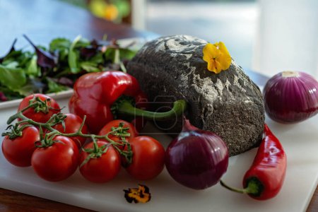 Foto de Pan casero recién horneado con tinta de sepia y verduras orgánicas de granja, tomates, cebollas, pimentón. Enfoque selectivo suave. - Imagen libre de derechos