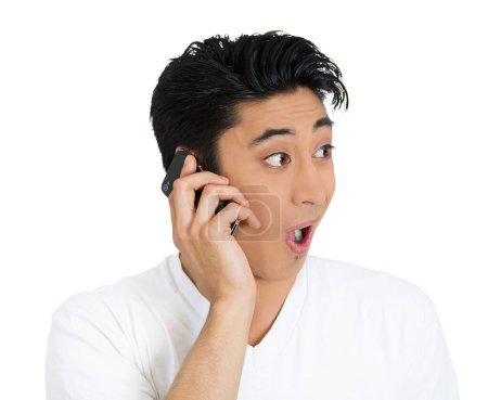 Téléchargez les photos : Choqué jeune homme parlant sur un téléphone - en image libre de droit