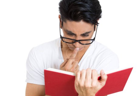 Closeup of a young man in glasses reading a book 
