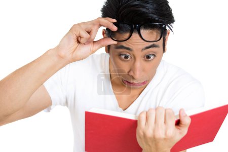 Photo for Portrait of young man, with wide opened eyes staring at a book page, shocked, surprised by the twists and turn of story, isolated on white background. - Royalty Free Image