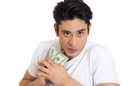 Porträt eines gierigen jungen Mannes, der Dollarnoten fest in der Hand hält, isoliert auf weißem Hintergrund.