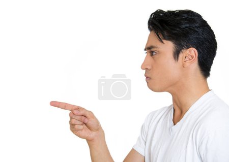 Closeup side view profile portrait of serious man, pointing with index finger at someone, isolated on white background