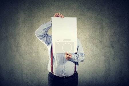 Téléchargez les photos : Un jeune homme joufflu tient une feuille de papier blanc devant son visage - en image libre de droit