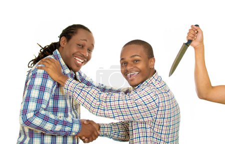 Fake friend backstabbing concept. Portrait hypocrite, crafty man gives handshake to a guy at same time trying to stab him in back with knife isolated white background. 