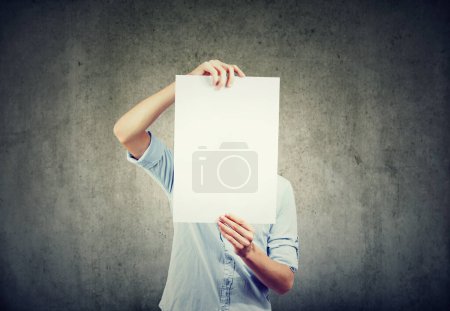Téléchargez les photos : Un jeune homme tient une feuille de papier blanc devant son visage - en image libre de droit