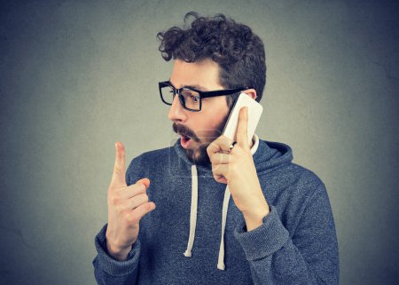 Shocked man talking on a cellphone 