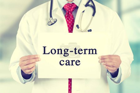 Primer plano de un profesional de la salud que sostiene un signo de atención a largo plazo 
