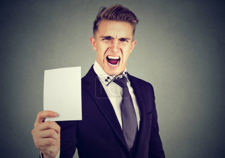 Joven hombre de negocios frustrado mostrando una tarjeta blanca en blanco