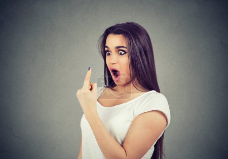 shocked young woman looking at her index finger