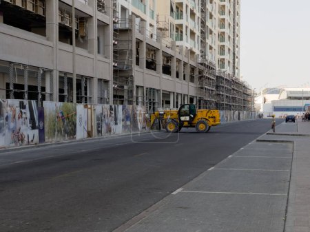 Téléchargez les photos : Dubai, United Arab Emirates - 6th December, 2021: A JCB 540 telehandler at work at a construction site, helping carry loads of heavy material from one place to another. - en image libre de droit