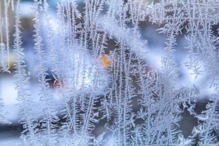 Foto de Cristales de nieve formados en la ventana durante los meses fríos del invierno. Fondo de invierno con calle - Imagen libre de derechos