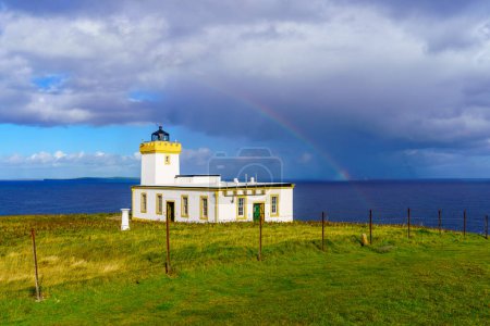 Photo for View of the Duncansby Head Lighthouse, with a rainbow, in the northeastern tip of Scotland, UK - Royalty Free Image