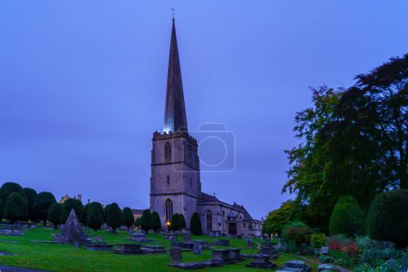 Photo for Painswick, UK - October 16, 2022: Evening view of the St Mary Church and its yard cemetery, in Painswick, the Cotswolds region, England, UK - Royalty Free Image