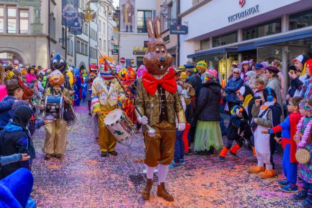 Téléchargez les photos : Lucerne, Suisse - 21 février 2023 : Groupe de participants en costumes défilent dans les rues, et la foule, une partie de la parade des enfants du Carnaval Fasnacht, à Lucerne (Lucerne), Suisse - en image libre de droit
