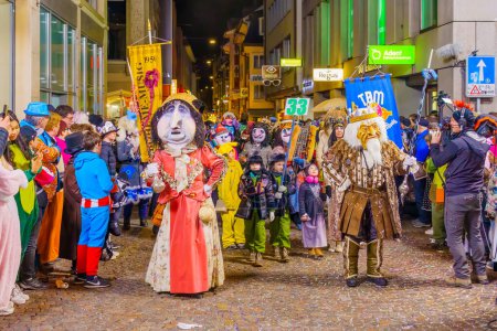 Lucerne, Switzerland - February 21, 2023: People in costumes take part of the final night parade of the Fasnacht Carnival, in Lucerne (Luzern), Switzerland