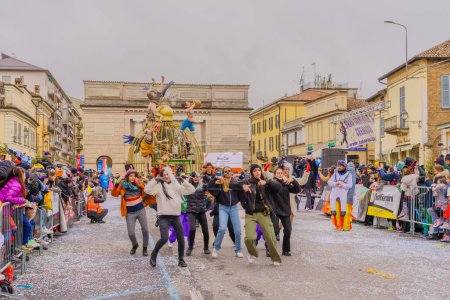 Photo for Crema, Italy - February 26, 2023: Carnival parade, with dancers in costumes, allegorical figure wagon, and crowd, in Crema, Lombardy, Northern Italy - Royalty Free Image
