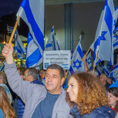 Téléchargez les photos : Haïfa, Israël - 25 mars 2023 : Des manifestants avec divers signes et drapeaux assistent à une manifestation contre les plans du nouveau gouvernement, affirmant son antidémocratique, à Haïfa, Israël - en image libre de droit