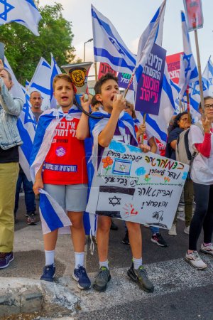 Foto de Haifa, Israel - 13 de mayo de 2023: Gente marchando con banderas y varios carteles. 19ª semana de protesta contra el gobierno en Haifa, Israel - Imagen libre de derechos