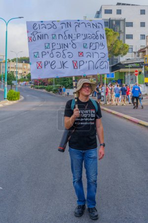 Téléchargez les photos : Haïfa, Israël - 10 juin 2023 : Groupe de personnes avec des signes anti-occupation. 23ème semaine de protestation anti-gouvernementale à Haïfa, Israël - en image libre de droit