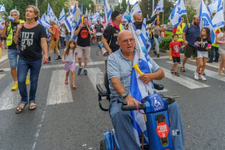 Téléchargez les photos : Haïfa, Israël - 17 juin 2023 : Des gens marchent avec des drapeaux et divers signes. Semaine 24 de protestation anti-gouvernementale à Haïfa, Israël - en image libre de droit