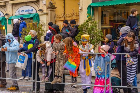 Photo for Crema, Italy - February 26, 2023: Spectators in costumes attend the Carnival parade, in Crema, Lombardy, Northern Italy - Royalty Free Image