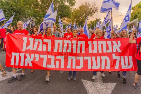 Photo for Haifa, Israel - July 22, 2023: People march with flags and various signs. Part of week 29 of protest against controversial judicial overhaul. Haifa, Israel - Royalty Free Image