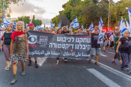 Téléchargez les photos : Haïfa, Israël - 29 juillet 2023 : Les gens marchent avec des signes anti-occupation. Une partie de la semaine 30 de protestation contre la révision judiciaire controversée. Haïfa, Israël - en image libre de droit