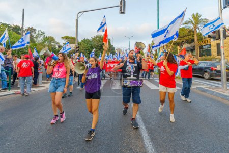 Téléchargez les photos : Haïfa, Israël - 19 août 2023 : Les gens défilent avec divers drapeaux et signes. Semaine 33 de protestation contre la révision judiciaire controversée. Haïfa, Israël - en image libre de droit