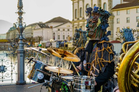 Téléchargez les photos : Lucerne, Suisse - 20 février 2023 : Des musiciens en costumes défilent sur le pont Reussbrucke, et la foule, dans le cadre du Carnaval de la Nuit, à Lucerne (Lucerne), Suisse - en image libre de droit