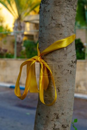 Photo for Haifa, Israel - October 26, 2023: Yellow ribbons on trees, as a symbolic call to bring back the people kidnapped to Gaza. Haifa, Israel - Royalty Free Image