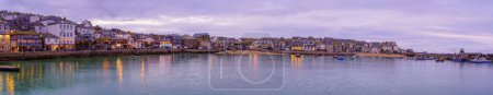 Téléchargez les photos : St Ives, Royaume-Uni - 14 octobre 2022 : Coucher de soleil panoramique sur le port, avec diverses entreprises, à St Ives, Cornouailles, Angleterre, Royaume-Uni - en image libre de droit