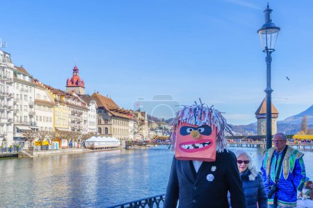 Téléchargez les photos : Lucerne, Suisse - 20 février 2023 : Participants en costumes et monuments de la ville en arrière-plan, dans le cadre du Carnaval de la Nuit, à Lucerne (Lucerne), Suisse - en image libre de droit