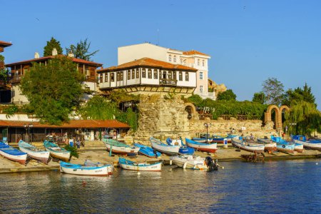 Photo for Nesebar, Bulgaria - September 20, 2023: Beach view with various boats and buildings, in the old town of Nesebar, Bulgaria - Royalty Free Image