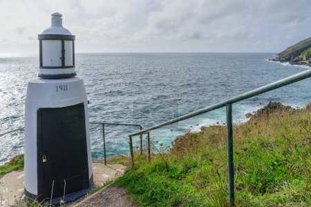 View of the Spy House Point Lighthouse (number marks the building year: 1911), in the fishing village Polperro, Cornwall, England, UK