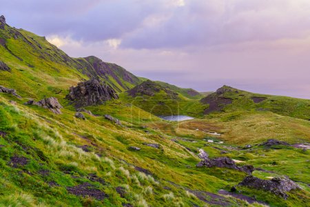 Coucher de soleil sur les rochers et l'herbe le long du sentier Old Man of Storr, dans l'île de Skye, Hébrides intérieures, Écosse, Royaume-Uni