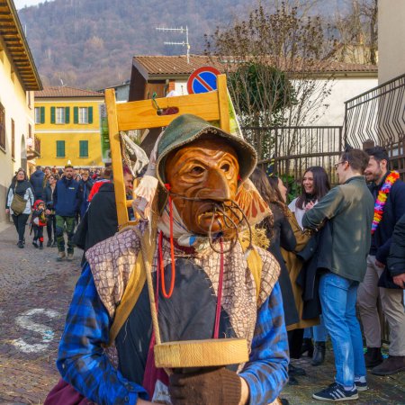 Photo for Schignano, Italy - February 18, 2023: Participants in traditional costumes and mask, and spectators, part of the traditional carnival of Schignano, Lake Como, Lombardy, Northern Italy - Royalty Free Image