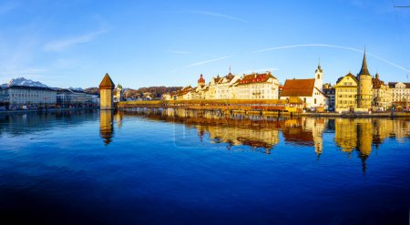 Photo for Lucerne, Switzerland - February 21, 2023: Panoramic sunrise view of the Chapel Bridge, the Jesuit Church St Francis Cavier, and the Reuss River, in Lucerne (Luzern), Switzerland - Royalty Free Image