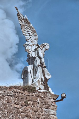 Téléchargez les photos : 04-09-2012 Comillas, Espagne - Sculpture d'ange ailé avec épée au cimetière Comillas - en image libre de droit