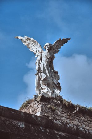 Téléchargez les photos : 04-09-2012 Comillas, Espagne - Sculpture d'ange ailé avec épée au cimetière Comillas - en image libre de droit