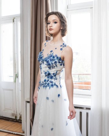 Téléchargez les photos : Une femme en robe blanche avec des fleurs bleues - en image libre de droit