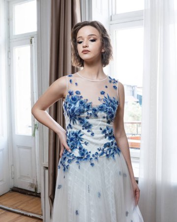 Téléchargez les photos : Une femme en robe blanche avec des fleurs bleues - en image libre de droit