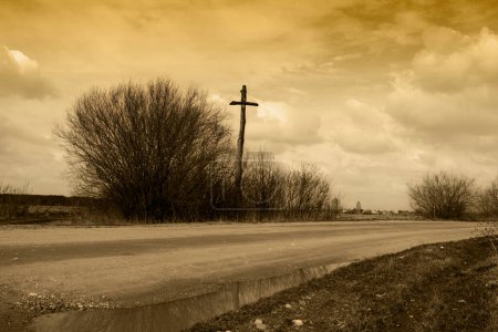 Téléchargez les photos : Une vieille croix de bois sur une route rurale sablonneuse, symbole des habitants des environs - en image libre de droit