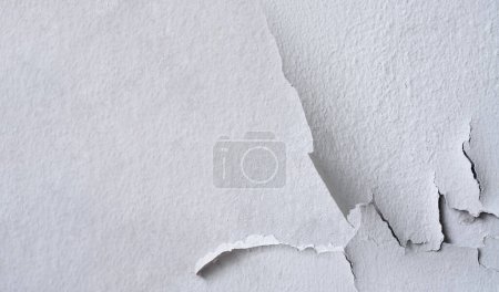 Foto de Pintura de color blanco agrietado sobre fondo de pared de cemento, superficie de hormigón rugoso roto - Imagen libre de derechos