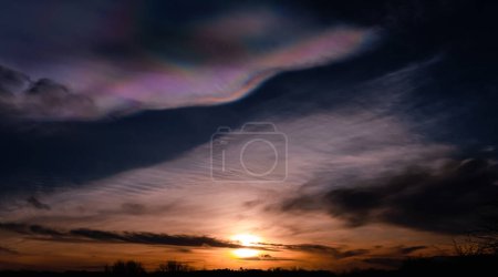 Photo for Beautiful Iridescent Pileus Cloud Over Sunset,Rare Natural of Sunset Sky of Fire Rainbows or Rainbow Clouds.Dark Cloud with Colourful optical Phenomenon sky in Winter Evening in UK - Royalty Free Image